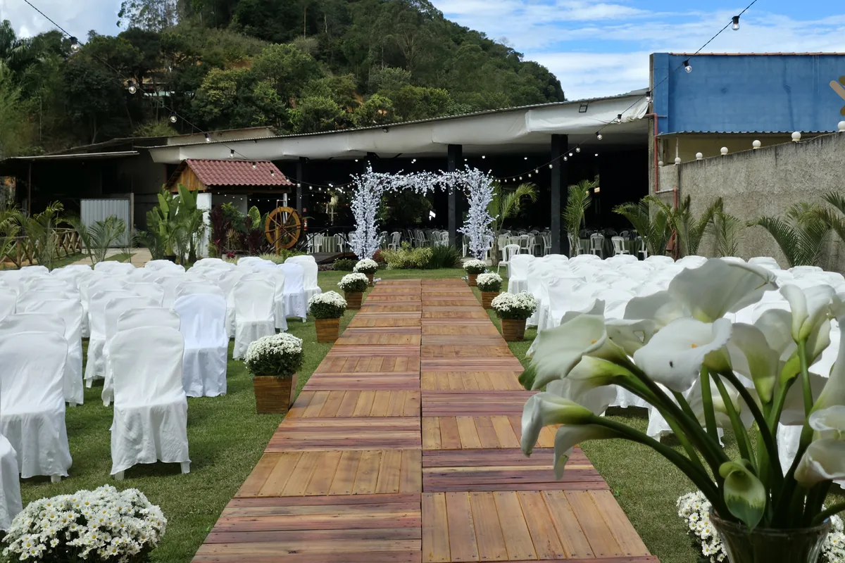Cerimônia montada no gramado, com passarela de madeira e a mata ao fundo