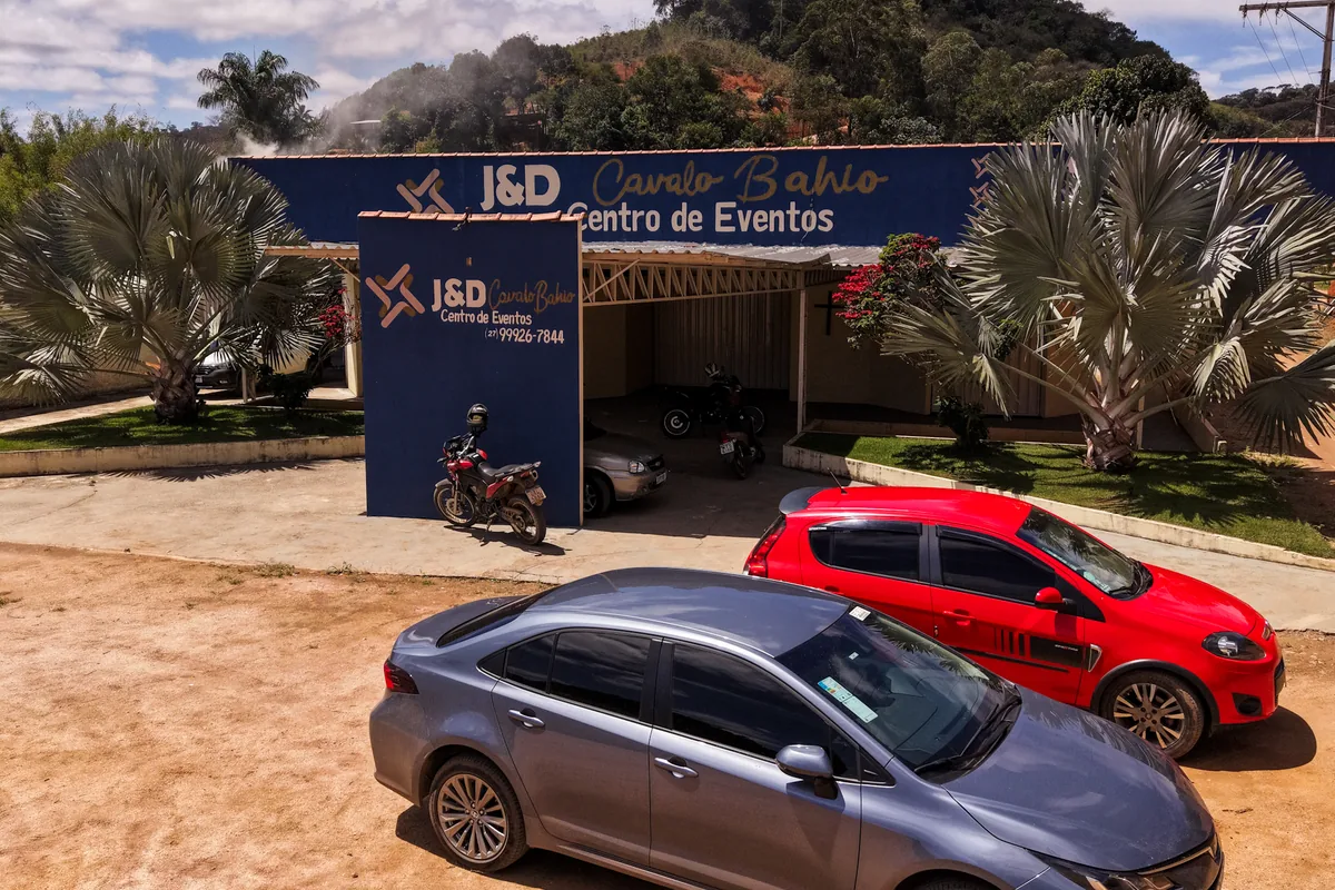 Entrada do centro de eventos, com o painel da J&D e o estacionamento